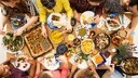 Gedeckter Tisch mit Menschen von oben gesehen.