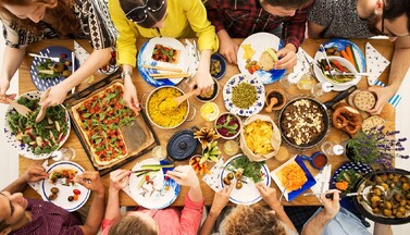 Gedeckter Tisch mit Menschen von oben gesehen.