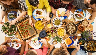 Gedeckter Tisch mit Menschen von oben gesehen.