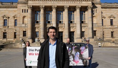 Sylvi Paulick, Mahi Klosterhalfen, Dimitar Gerganov und Christian Rehmer mit einem Banner vor dem Bundesverwaltungsgericht.