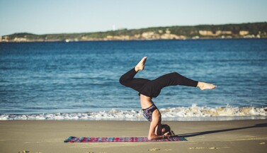 Frau macht Yoga am Strand.
